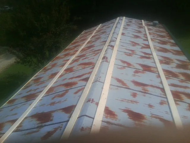 Rusted metal roof panels with new wood purlins before replacement — Storm Damage Roof Repair in Wimbledon by Roofing Brothers